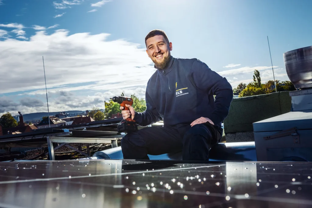 Elektrotechniker vor Photovoltaikanlage auf dem Dach