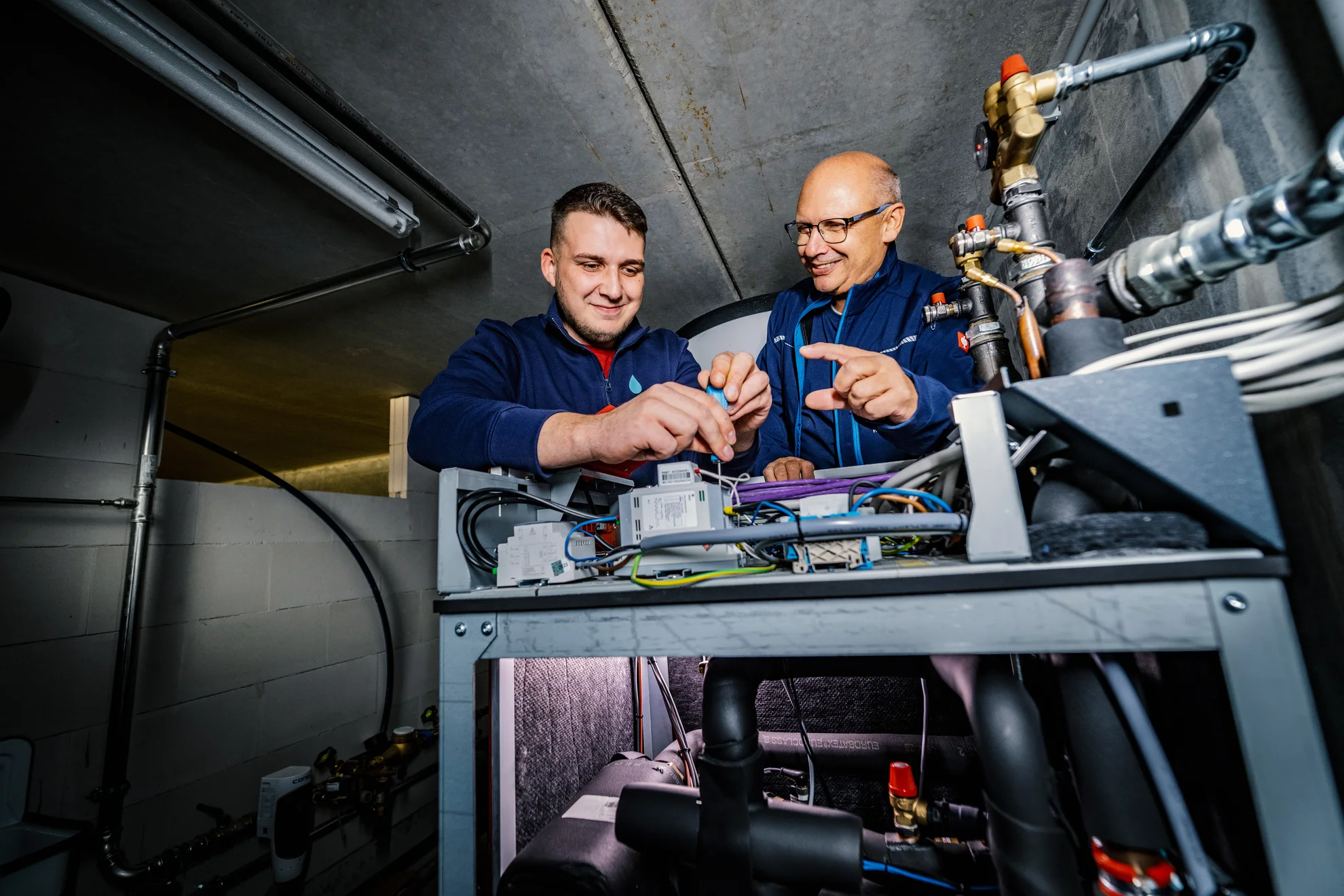 Ausbilder mit Azubi im Heizungskeller