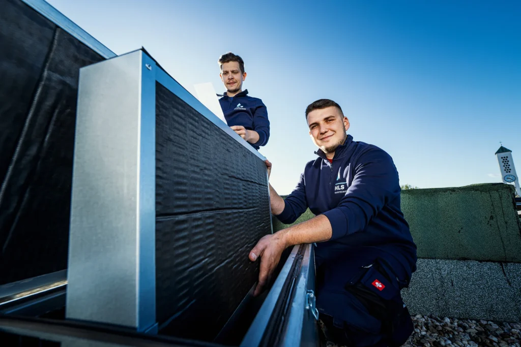 Monteure mit Klimaanlage auf einem Gebäudedach